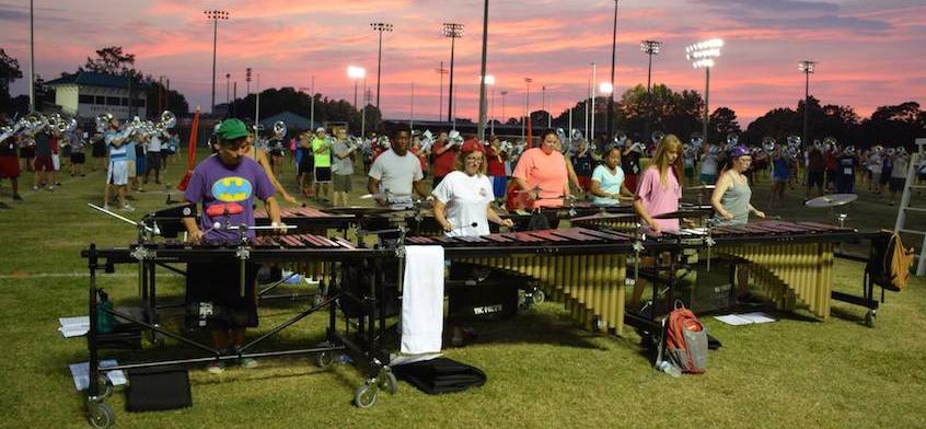Band practicing on field at dusk,